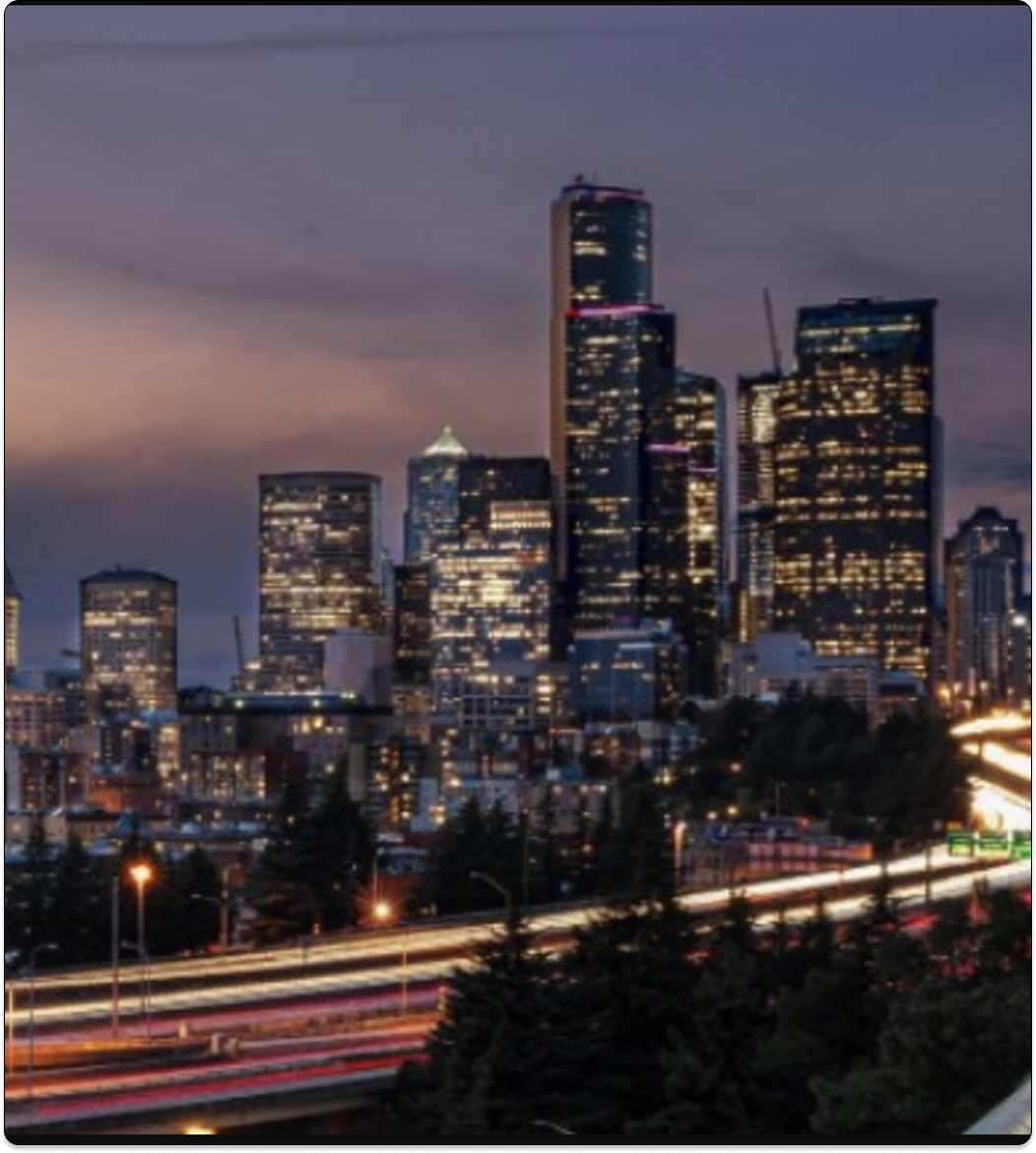 City skyline at night with highway